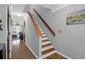 Staircase with wooden railing and white risers leads to the upper level of the home at 14 Town Park Ln # B, Charleston, SC 29412