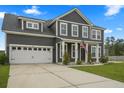 Traditional two-story home with attached garage, features manicured lawn, driveway, and neutral color scheme at 180 Basket Grass Ln, Summerville, SC 29486