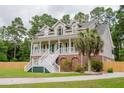 Beautiful home featuring a welcoming front porch, lush lawn, and mature landscaping at 187 Pecan Dr, Summerville, SC 29483