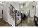 Bright living room features soaring ceilings, large windows, hardwood floors and decorative staircase at 1996 Wild Indigo Way, Hanahan, SC 29410