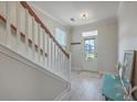 Bright foyer featuring wood-look floors, a white staircase with wood banister, and natural light at 2001 Poplar Grove Pl, Summerville, SC 29483