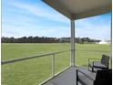 Relaxing screened-in porch with chairs overlooks vast, green lawn and mature trees in this desirable community at 215 Sweet Cherry Ln, Summerville, SC 29486