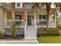 Close-up of the home's entry way with a charming front porch and manicured landscaping at 225 Hanahan Plantation Cir, Hanahan, SC 29410