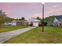 Exterior view of a brick home with an attached garage and a mature lawn at 234 Two Hitch Rd, Goose Creek, SC 29445