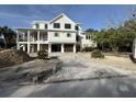 Stunning home features a garage, porch, and brick driveway, enhancing its curb appeal and functionality at 2870 Ion Ave, Sullivans Island, SC 29482