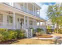 Close-up of home exterior featuring a columned porch and beautifully landscaped yard at 301 Hidden Bottom Ln, Daniel Island, SC 29492