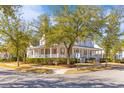 Corner view of a classic home featuring a sprawling porch and lush landscaping at 301 Hidden Bottom Ln, Daniel Island, SC 29492