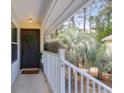 Front porch with dark door, a wreath, and outdoor plants with a serene view of palm trees at 341 W Coleman Blvd # F, Mount Pleasant, SC 29464