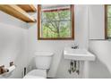 Cozy bathroom features a toilet, sink, window and wall shelves, creating a functional space at 394 Shoofly Rd, Ridgeville, SC 29472
