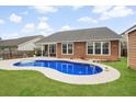 This backyard features a beautiful kidney shaped pool, patio area and well-maintained lawn at 404 Ambergate Ln, Moncks Corner, SC 29461