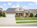 Charming single story home featuring well-manicured lawn, landscaping, covered porch, and two car garage at 404 Ambergate Ln, Moncks Corner, SC 29461