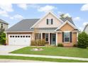 Charming single story home featuring well-manicured lawn, landscaping, covered porch, and two car garage at 404 Ambergate Ln, Moncks Corner, SC 29461