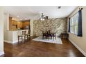 Bright dining area with wood floors, a stone accent wall, and access to a modern kitchen with granite countertops at 4120 Veritas St, Charleston, SC 29414