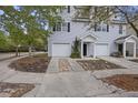Lovely townhome showcasing a one-car garage, black shutters, and meticulous landscaping leading to the front entrance at 4120 Veritas St, Charleston, SC 29414