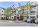 Multi-story condo building featuring a brick entrance, manicured landscaping, and convenient parking spaces at 45 Sycamore Ave # 116, Charleston, SC 29407