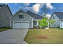Well-maintained home with an attached garage, green lawn, and a young tree in the front yard at 603 Dunswell Dr, Summerville, SC 29486