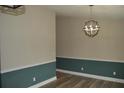 Dining room featuring two-tone walls, modern light fixture, and wood-look flooring at 708 Old State Rd, Goose Creek, SC 29445