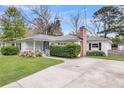 Charming one-story home with a concrete driveway and manicured lawn offers great curb appeal at 734 W Oak Forest Dr, Charleston, SC 29407