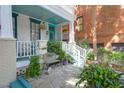 Inviting front porch with teal ceilings, painted brick accents and a charming seating area at 78 Society St, Charleston, SC 29401
