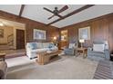 Spacious living room featuring wood paneling, neutral carpeting, and comfortable sofas and chairs at 8147 Waltham Rd, North Charleston, SC 29406
