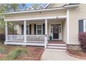 Inviting front porch with white columns, a wreath on the door, and a landscaped yard at 8618 Mcchune Ct, North Charleston, SC 29420