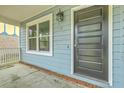 Inviting front porch with black front door, white railing, and blue wood siding at 107 Lewisfield Dr, North Charleston, SC 29418
