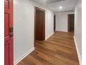 Inviting hallway with hardwood floors, white walls and red door providing a warm and spacious walkway at 1085 Russellville Rd, Saint Stephen, SC 29479