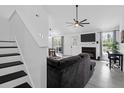 Open-concept living room with fireplace, ceiling fan, and staircase, perfect for relaxation and gatherings at 1174 Pittsford Cir, Charleston, SC 29412