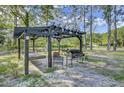 Wooden pergola with a swing bench, a bbq and a comfortable seating area at 130 Oak Crest Dr, Moncks Corner, SC 29461