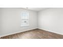 Well-lit bedroom features durable laminate flooring and a large window providing ample natural light at 131 River Hill Rd, Goose Creek, SC 29445