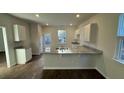 Bright kitchen featuring granite countertops, white cabinets, stainless steel sink, and modern lighting fixtures at 131 River Hill Rd, Goose Creek, SC 29445