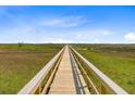 Scenic long wooden boardwalk stretching across marshland under a blue sky at 1479 Mossy Branch Way, Mount Pleasant, SC 29464