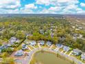 Breathtaking aerial view of a neighborhood with lush trees and a tranquil pond at 1529 Tomato Farm Cir, Mount Pleasant, SC 29464