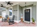 Cozy front porch with rocking chairs, brick flooring, and stylish accents creating a warm and inviting entrance at 158 Garden Lily Ln, Summerville, SC 29485