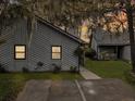 Charming home exterior with gray siding and driveway and lawn with trees nearby at 2196 Spoleto Ln, North Charleston, SC 29406