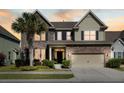 Beautiful two-story home features a stone facade, inviting entrance, a manicured lawn, and a mature palm tree at 2254 Show Basket Way, Mount Pleasant, SC 29466