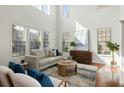 Bright living room with soaring ceilings, large windows, and stylish neutral furniture on hardwood floors at 2254 Show Basket Way, Mount Pleasant, SC 29466