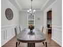 Formal dining room featuring hardwood floors, wainscoting, a chandelier, and a large window at 280 Swamp Creek Ln, Moncks Corner, SC 29461