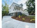 Beautiful two-story home featuring a spacious front porch, manicured landscaping, and a concrete driveway at 295 W Coleman Blvd, Mount Pleasant, SC 29464