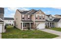 A view of a two story home featuring a two-car garage and well-manicured lawn at 320 Silverleaf Ln, Moncks Corner, SC 29461