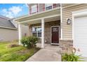 Inviting front entrance with brick accents, a covered porch, and a stylish front door at 320 Silverleaf Ln, Moncks Corner, SC 29461