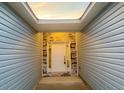 Covered entryway featuring a white front door with sidelights, a stone accent wall, and light blue siding at 3292 N Highway 52, Saint Stephen, SC 29479