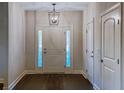 Foyer with hardwood floors, three-paneled white front door with sidelights, and designer light fixture at 3292 N Highway 52, Saint Stephen, SC 29479