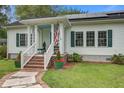 Inviting front porch with brick steps, white railings, and planters with colorful flowers at 3378 Von Ohsen Rd, Ladson, SC 29485