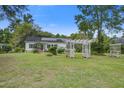 Charming home with a spacious lawn, a pergola, mature trees, and solar panels on the roof at 3378 Von Ohsen Rd, Ladson, SC 29485