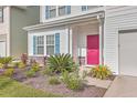 Close-up of a home's colorful pink front door framed by vibrant landscaping and charming blue shutters at 353 Dunlin Dr, Summerville, SC 29486