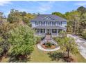Beautiful home in a treed lot, featuring an elevated porch, landscaped lawn, and large windows at 3734 St Ellens Dr, Mount Pleasant, SC 29466