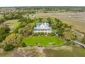 Beautiful aerial view of home nestled in mature trees with a metal roof and lush green lawn at 377 Lofton Ct, McClellanville, SC 29458