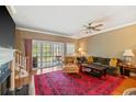 Cozy living room featuring a fireplace, ceiling fan, and sliding glass doors to a balcony at 5276 7Th Green Dr, Hollywood, SC 29449