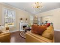 Cozy living room featuring a fireplace, modern lighting fixture, and hardwood floors at 547 Pontoon Rd, Huger, SC 29450